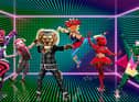 Five Masked Dancers - Sea Slug, Pig, Pearly King, Onomatopoeia, Tomato Sauce and Cactus - pose on an electric green soundstage (Credit: ITV)