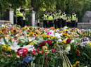 Police officers arrive at the gates of Balmoral in Scotland where flowers and tributes have been laid by members of the public following the death of Queen Elizabeth II. The Queen's coffin will be transported on a six-hour journey from Balmoral to the Palace of Holyroodhouse in Edinburgh, where it will lie at rest. Picture date: Sunday September 11, 2022.