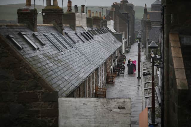 A resident cleans her house in the Footdee area in Aberdeen, Scotland.