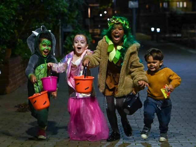 Children pose for a picture as they go trick-or-treating for Halloween in east London. 