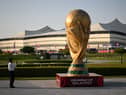 A man takes a picture of a FIFA World Cup trophy replica in front of the Al-Bayt Stadium in al-Khor on November 10, 2022, ahead of the Qatar 2022 FIFA World Cup football tournament. (Photo by Kirill KUDRYAVTSEV / AFP) (Photo by KIRILL KUDRYAVTSEV/AFP via Getty Images)
