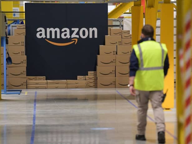 A US giant Amazon employee passes by its logo on the opening day of the new distribution center in Augny, eastern France, on September 23, 2021. (Photo by SEBASTIEN BOZON/AFP via Getty Images)