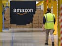 A US giant Amazon employee passes by its logo on the opening day of the new distribution center in Augny, eastern France, on September 23, 2021. (Photo by SEBASTIEN BOZON/AFP via Getty Images)