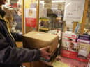 Customers weigh packages at the post office.