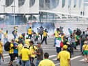 Supporters of Brazilian former President Jair Bolsonaro clash with the police during a demonstration outside the Planalto Palace in Brasilia on January 8, 2023. - Brazilian police used tear gas Sunday to repel hundreds of supporters of far-right ex-president Jair Bolsonaro after they stormed onto Congress grounds one week after President Luis Inacio Lula da Silva's inauguration, an AFP photographer witnessed. (Photo by EVARISTO SA / AFP) (Photo by EVARISTO SA/AFP via Getty Images)