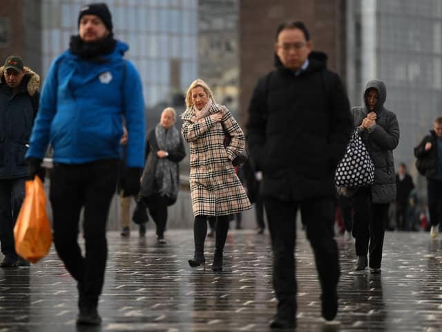Commuters on their way to work cross London Bridge in central London.