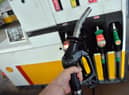 A man poses holding a petrol pump nozzle at a filling station in Birkenhead, north-west England.  (Photo credit should read PAUL ELLIS/AFP via Getty Images)