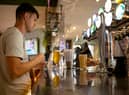 A customer buys a drink at a Wetherspoons pub in Clapham, London.
