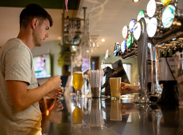 <p>A customer buys a drink at a Wetherspoons pub in Clapham, London.</p>