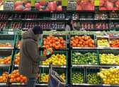 A customer shops for food items inside a Tesco supermarket store in east London on January 10, 2022.  (Photo by DANIEL LEAL/AFP via Getty Images)