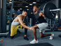 Man with his trainer in gym (Adobe)