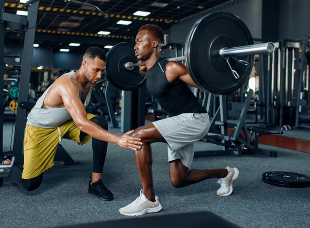 <p>Man with his trainer in gym (Adobe)</p>