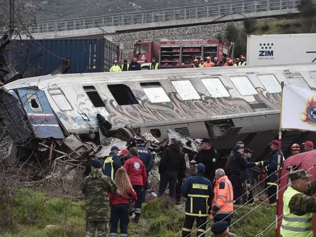 Police and emergency crews search wreckage after a train accident in the Tempi Valley near Larissa, Greece, March 1, 2023. - At least 32 people were killed and another 85 injured after a collision between two trains caused a derailment near the Greek city of Larissa late at night on February 28, 2023, authorities said. A fire services spokesman confirmed that three carriages skipped the tracks just before midnight after the trains -- one for freight and the other carrying 350 passengers - collided about halfway along the route between Athens and Thessaloniki. (Photo by Sakis MITROLIDIS / AFP) (Photo by SAKIS MITROLIDIS/AFP via Getty Images)