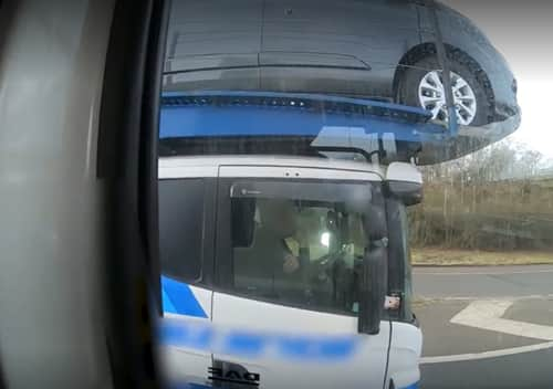 Footage shows the driver using his elbow to control the car transporter (Photo: Highways England) 