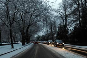 Cars drive on snowy roads in Liverpool.