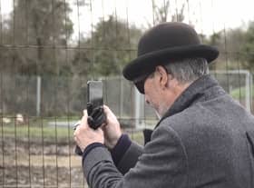 A mystery man in a bowler hat has been seen scoping out a famous site where the illusive artist Banksy left a mural that was inadvertently torn down by builders