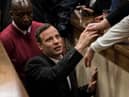 Olympic athlete Oscar Pistorius holds the hand of a relative after sentencing at the High Court on July 6, 2016 at the High Court in Pretoria, South Africa. Pistorius was sentenced to six years in prison for the murder of girlfriend Reeva Steenkamp at their home in 2013.