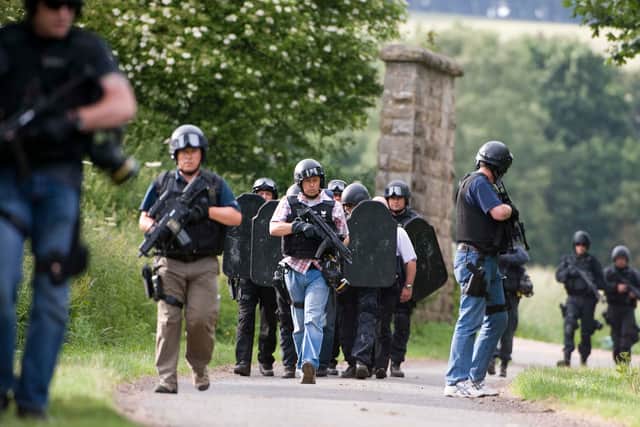 Armed police can be seen in the woods surrounding Rothbury in the continued search for Raoul Moat, in Rothbury, northeast England on July 7, 2010. British police offered a 10,000-pound (15,000-dollar, 12,000-euro) reward Wednesday for the capture of a fugitive suspected of shooting three people in northeast England.