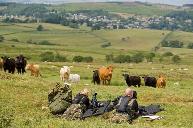 Police marksmen lie in the grass during their search for Raoul Moat, on the hills surrounding Rothbury, in northeast England on July 7, 2010.