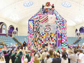 People watch as workers place a giant bobble on top of a 23 foot high bobble hat in celebration of the 20th anniversary of the innocent Big Knit in partnership with Age UK (photo: Dominic Lipinski/PA Wire)