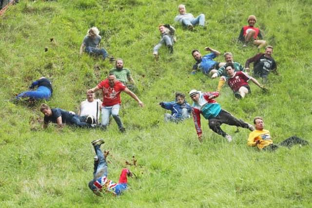 Annual Cheese Chase on Cooper's Hill in Gloucester sees competitors chase a Double Gloucester cheese down a 200-yard-long (183m) hill (photo: Getty Images)sus