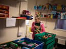 A worker at the Coventry Foodbank centre in Queens Road Baptist Church collates donated food items into parcels that will be provided to people arriving with a foodbank voucher.