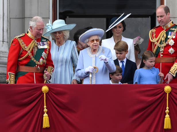 Britain's Queen Elizabeth II (C) stands with from left, Britain's Prince Charles, Prince of Wales, Britain's Prince Louis of Cambridge, Britain's Catherine, Duchess of Cambridge, Britain's Prince George of Cambridge, Britain's Princess Charlotte of Cambridge, and Britain's Prince William, Duke of Cambridge, to watch a special flypast from Buckingham Palace balcony following the Queen's Birthday Parade, the Trooping the Colour, as part of Queen Elizabeth II's platinum jubilee celebrations, in London on June 2, 2022.  (Photo by DANIEL LEAL/AFP via Getty Images)
