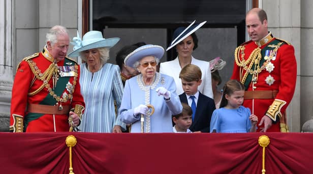 Britain's Queen Elizabeth II (C) stands with from left, Britain's Prince Charles, Prince of Wales, Britain's Prince Louis of Cambridge, Britain's Catherine, Duchess of Cambridge, Britain's Prince George of Cambridge, Britain's Princess Charlotte of Cambridge, and Britain's Prince William, Duke of Cambridge, to watch a special flypast from Buckingham Palace balcony following the Queen's Birthday Parade, the Trooping the Colour, as part of Queen Elizabeth II's platinum jubilee celebrations, in London on June 2, 2022.  (Photo by DANIEL LEAL/AFP via Getty Images)
