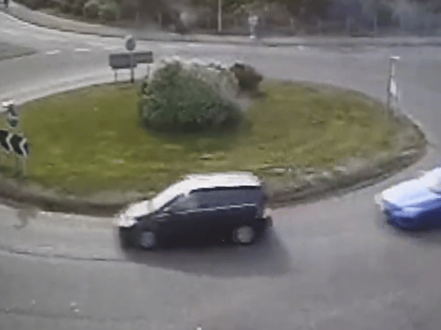 The moment a driver put their Need for Speed to the test as they drift around a busy roundabout.