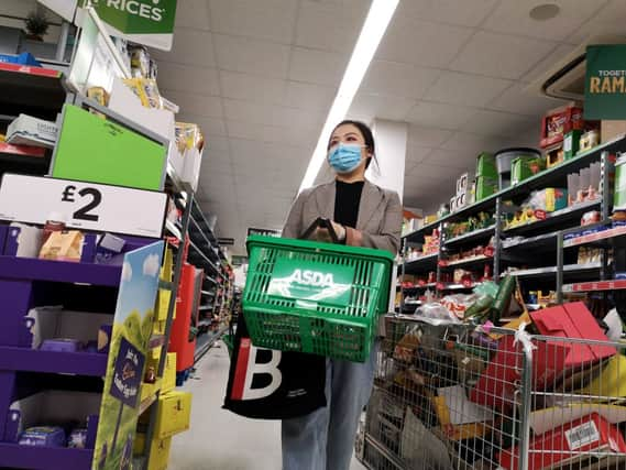 A shopper wears a protective mask as she walks down an aisle in a supermarket (Getty Images)