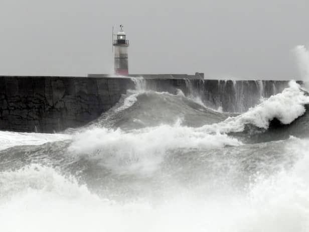 Waves crash over the breakwater by Newhaven Lighthouse as Storm Barra passes through Newhaven, southern England on December 7, 2021. (Photo by GLYN KIRK / AFP) (Photo by GLYN KIRK/AFP via Getty Images)