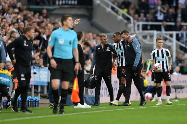 Joe Willock is helped off the pitch.