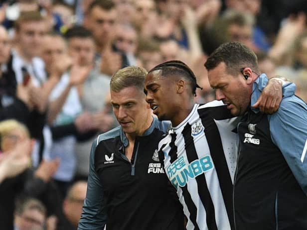 Newcastle United's Joe Willock is helped off the pitch.