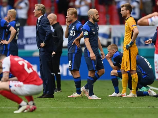 Markku Kanerva, Head Coach of Finland and Teemu Pukki of Finland wait on the pitch as Christian Eriksen (Not pictured) of Denmark receives medical treatment during the UEFA Euro 2020 Championship Group B match between Denmark and Finland on June 12, 2021 in Copenhagen, Denmark. (Photo by Stuart Franklin/Getty Images)