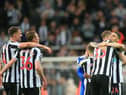 Newcastle United players embrace at the final whistle.