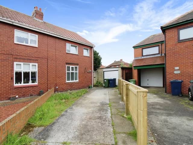 The front of the property has a long driveway and detatched garage