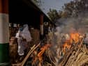 A priest avoids funeral pyres in India, which has been badly hit by a surge in coronavirus cases. (Photo by Anindito Mukherjee/Getty Images)