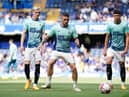 Anthony Gordon, Kieran Trippier and Lewis Miley warm up at Stamford Bridge.