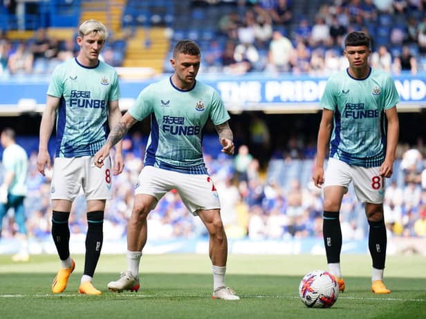 Anthony Gordon, Kieran Trippier and Lewis Miley warm up at Stamford Bridge.
