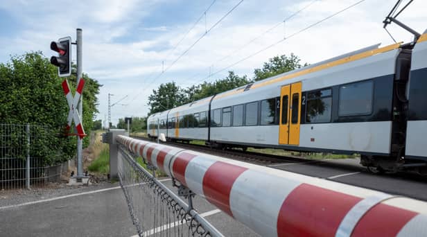 A CCTV clip has shown the heart-stopping moment a woman has a near miss with a train on a level crossing