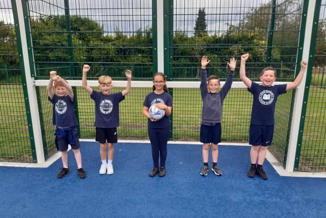 Children celebrate the opening of their new multi use games area.