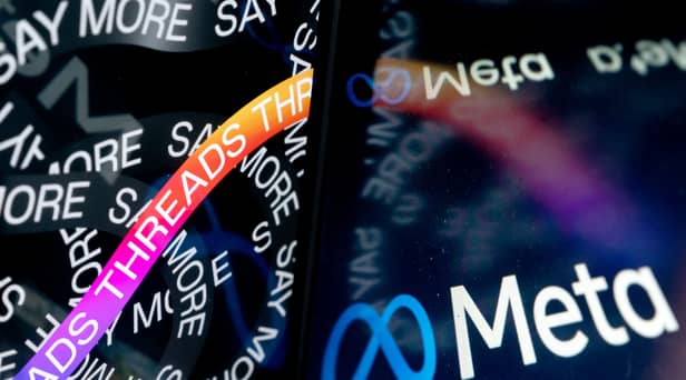 The opening page of Threads, an Instagram app, near the Meta logo. (Photo by STEFANI REYNOLDS/AFP via Getty Images)