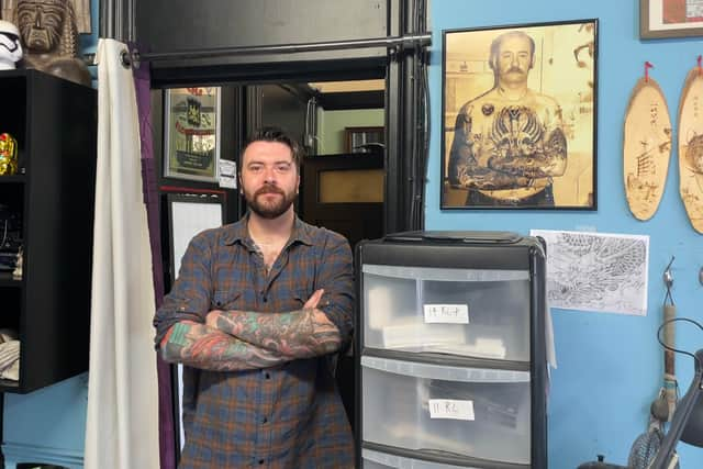 Harry’s Tattoo Studio owner Craig Low alongside a photo of Harry. 