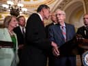 WASHINGTON, DC - JULY 26: (L-R) Sen. John Barrasso (R-WY) reaches out to help Senate Minority Leader Mitch McConnell (R-KY) after McConnell froze and stopped talking at the microphones during a news conference after a lunch meeting with Senate Republicans U.S. Capitol 26, 2023 in Washington, DC. Also pictured, L-R, Sen. Shelley Moore Capito (R-WV), Sen. Steve Daines (R-MT), and Sen. John Thune (R-SD). McConnell was escorted back to his office and later returned to the news conference and answered questions.  (Photo by Drew Angerer/Getty Images)