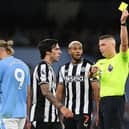 Robert Jones shows a yellow card to Sandro Tonali of Newcastle United during the Premier League match between Manchester City and Newcastle United at Etihad Stadium on August 19, 2023 in Manchester, England.