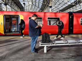 Commuters walk past a train stopped at a platform in Waterloo Station in London, during a national strike day, on February 1, 2023.