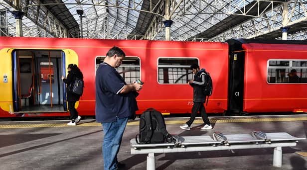 Commuters walk past a train stopped at a platform in Waterloo Station in London, during a national strike day, on February 1, 2023.