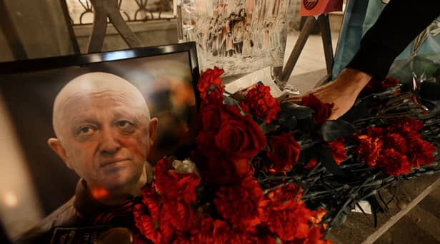  A man lays flowers at a makeshift memorial in honour of Yevgeny Prigozhin.