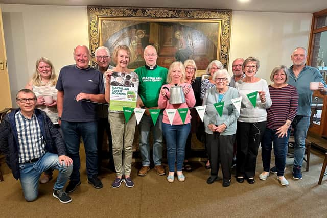 Submitted group shot of volunteers with Reverend Paul Barker (green t-shirt) getting ready for the coffee morning with promotional items from Macmillan.