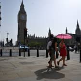 Pedestrians walk in the midday sun past the Palace of Westminster in central London on September 6, 2023 as the late summer heatwave continues.